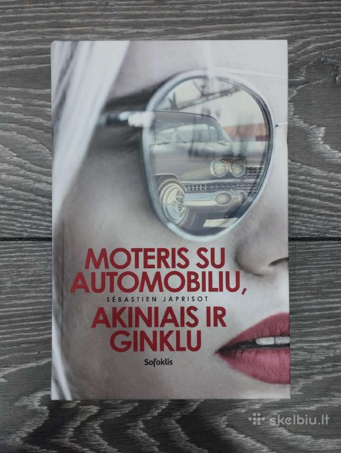 Moteris su automobiliu, akiniais ir ginklu