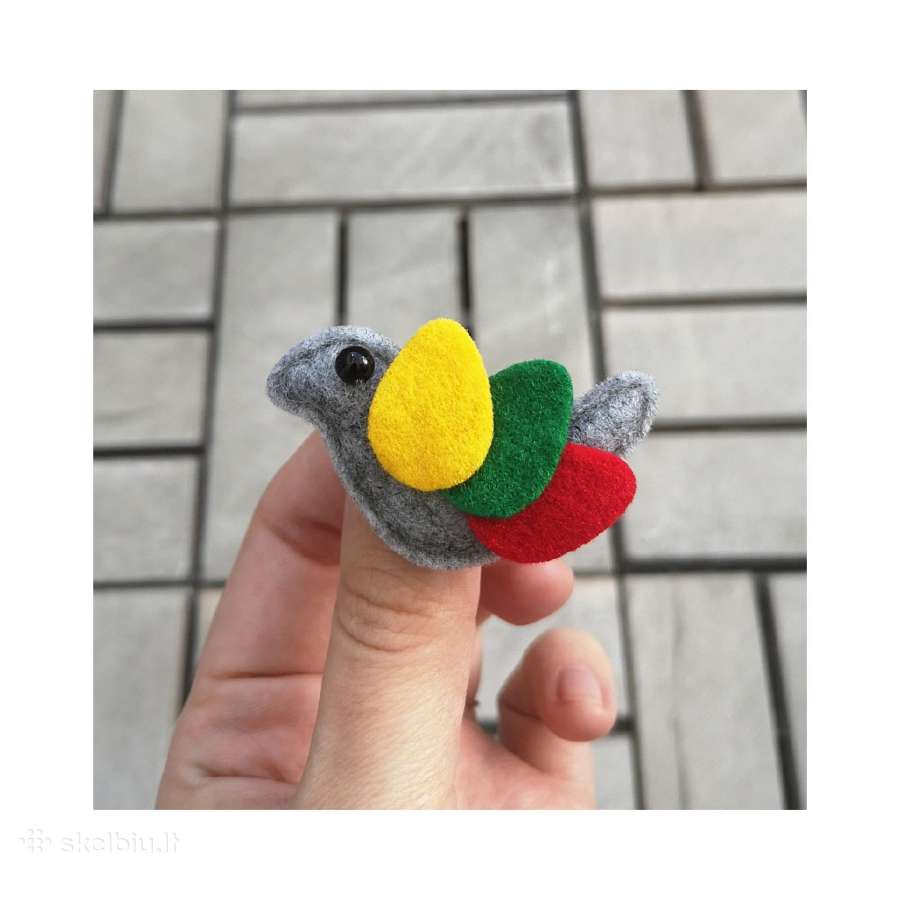 Segė paukštelis su trispalviu sparneliu.