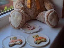 Didelis Teddy meškinas su lėkštutėmis.