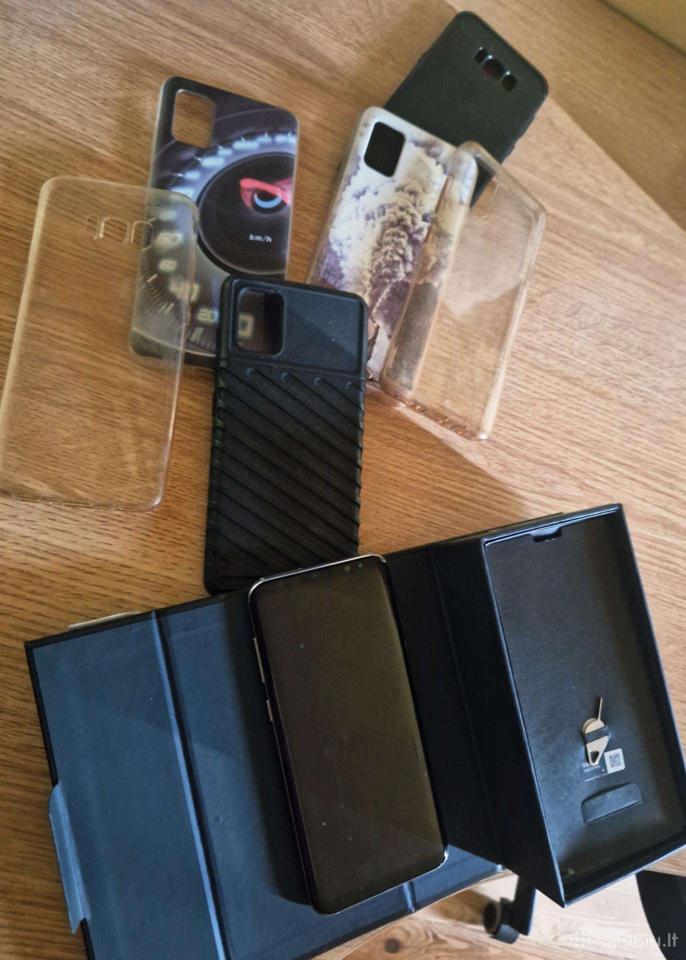 Trys mobilūs telefonai, trejos belaidės ausinės.