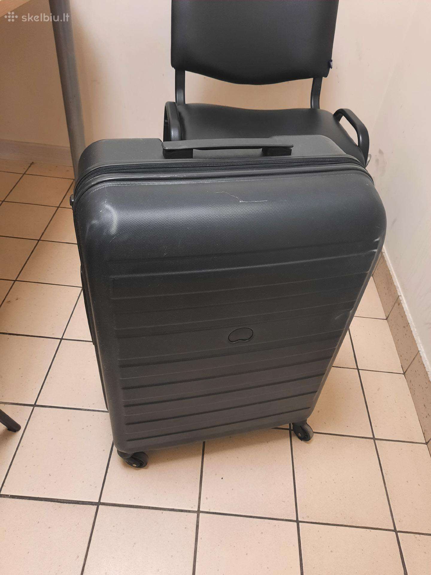 Didelis juodas kelioninis lagaminas ant ratu